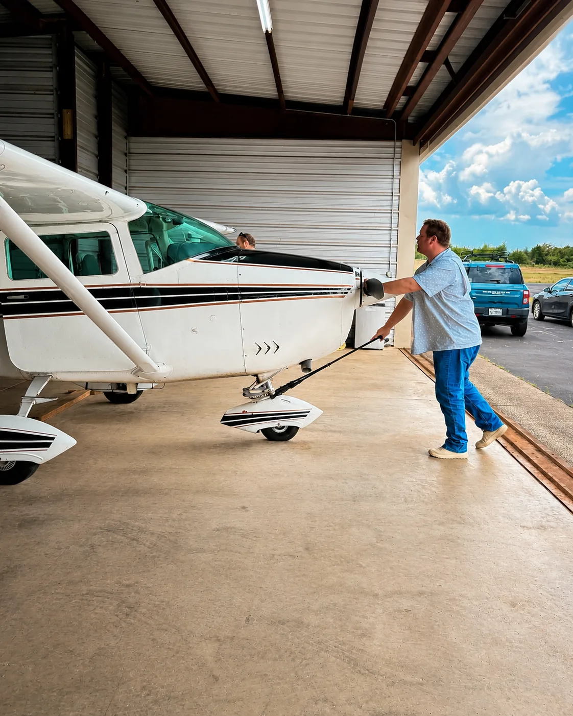 Pilot carefully moving a general aviation aircraft into a hangar