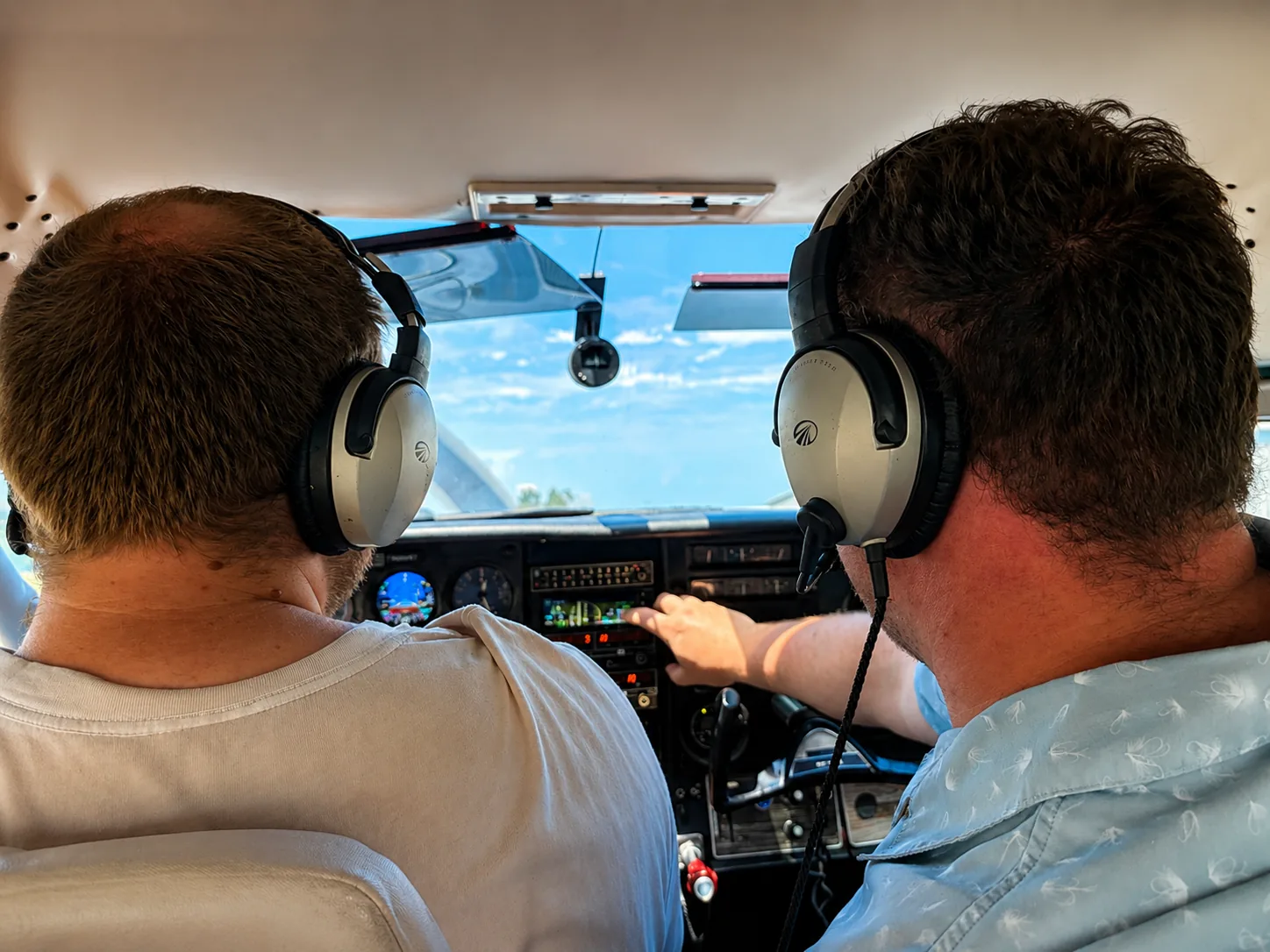 Instructor discussing cockpit avionics with a pilot in flight